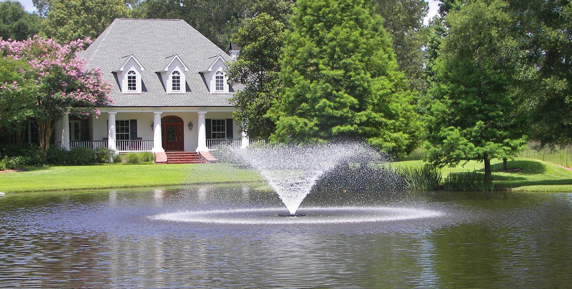 House with a pond and fountain in a suburban setting